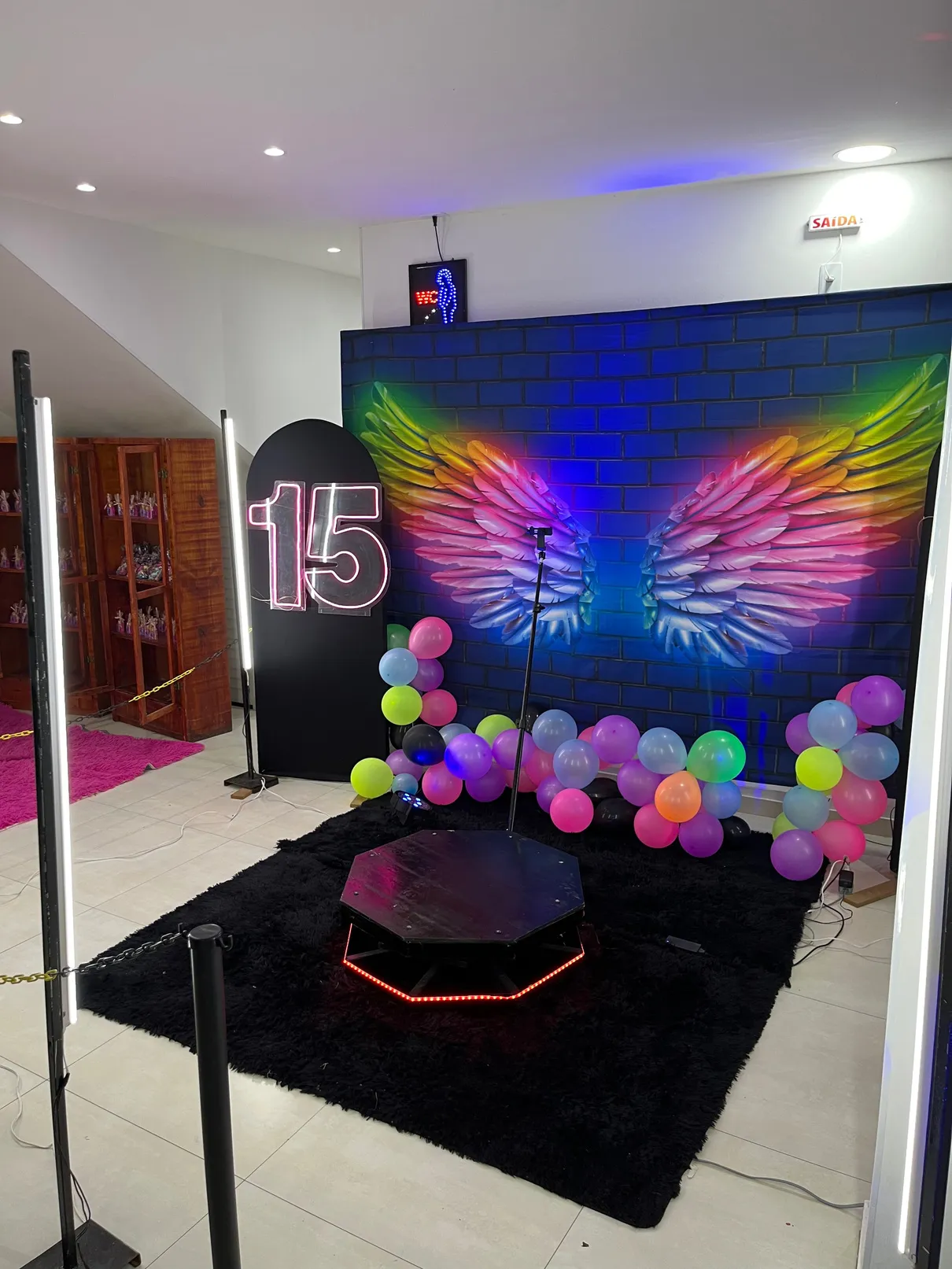 Plataforma D-PLAY 360 montada em festa de 15 anos com decoração em neon e balões.